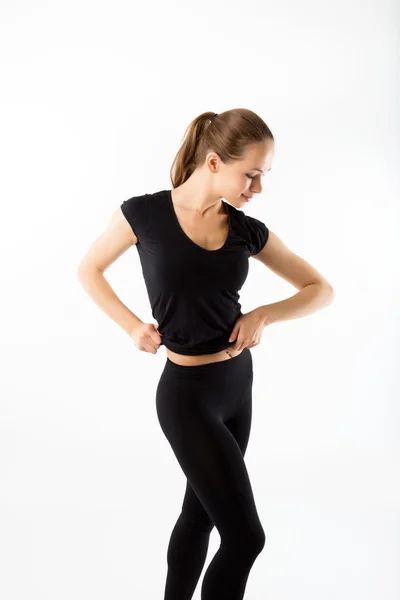 Mujer joven en forma. En la ropa deportiva negro sobre fondo blanco — Foto de Stock