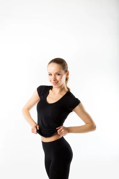 Mujer joven en forma. En la ropa deportiva negro sobre fondo blanco —  Fotos de Stock