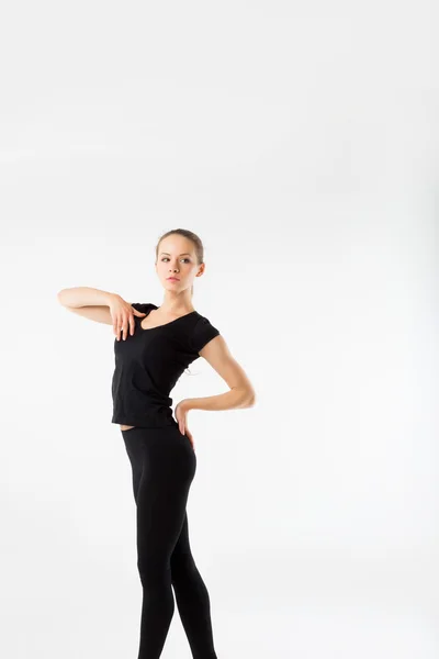 Молодая женщина фитнес. В черной спортивной одежде на белом трико — стоковое фото