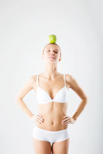 Mujer joven meditando con manzana en la cabeza — Foto de Stock