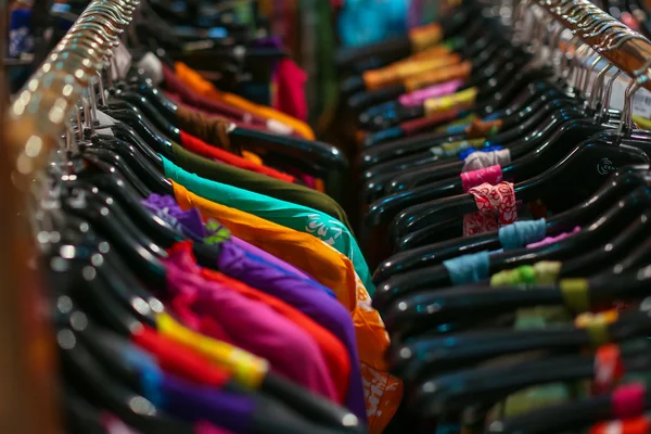 Colgaron un estante de camisas de colores para la venta en una feria — Foto de Stock