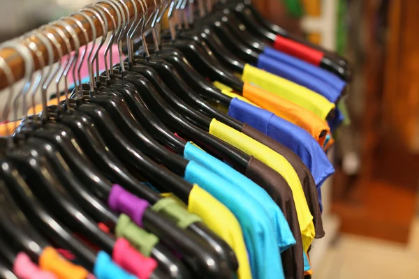 A rack of colorful shirts hanged for sale at a fair — Stock Photo, Image