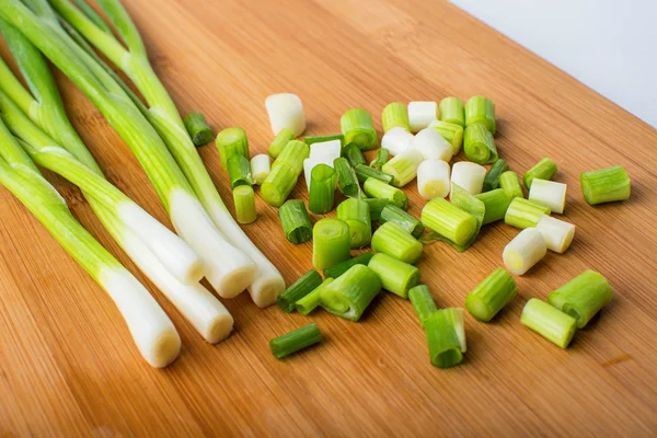 Cebolla verde primavera sobre tabla de madera — Foto de Stock