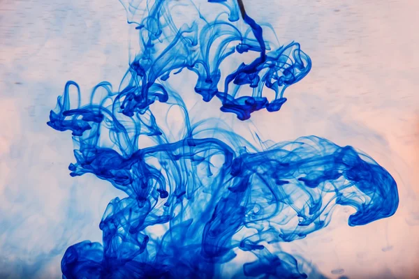 Abstracte blauwe verf druppels in water — Stockfoto