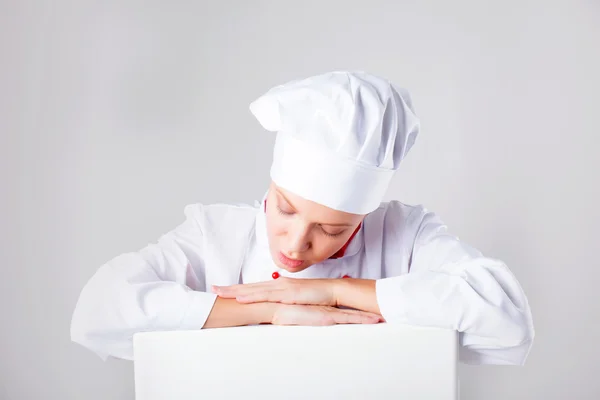 Kochzeichen. Bäckerin schaut über Werbetafel. überrascht und lustig Ausdruck Frau isoliert auf weißem Hintergrund. — Stockfoto