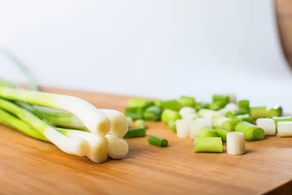 Oignon vert printemps sur planche en bois — Photo