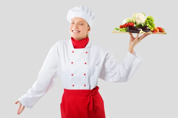 Kucharz trzyma w jednej ręce tacę drewniane. gotować z warzywami góra zabronione — Zdjęcie stockowe