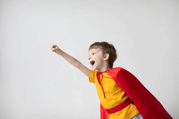Весёлый Ребёнок Играет Супергероя Красном Плаще Протягивая Руку Мальчик Сверхдержав — стоковое фото