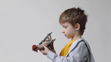 Evin içinde klasik ahşap uçakla oynayan bir çocuk. Çocuk evde eğleniyor..