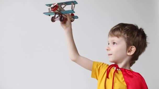Malý Zasněný Superhrdina Červeném Plášti Hrající Dřevěnou Hračku Létající Letadle — Stock video