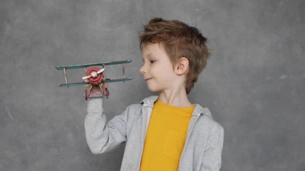 Criança Sonhadora Brincando Com Avião Brinquedo Madeira Interior Fundo Cinza — Vídeo de Stock