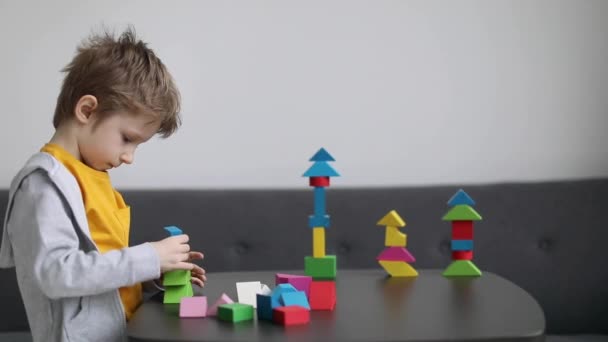 Kleiner Junge Baut Haus Aus Bunten Holzklötzen Wohnzimmer Zeitlupenaufnahmen — Stockvideo