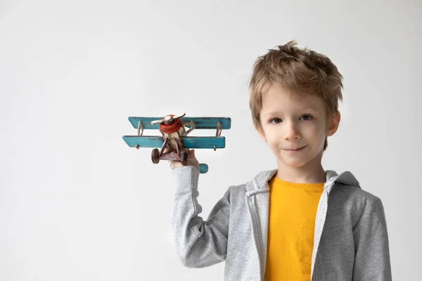 手に木製の飛行機で幸せな少年遊び 子供の旅行についての夢 幸福と自由の概念 — ストック写真