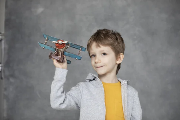 手に木製の飛行機で幸せな少年遊び 子供の旅行についての夢 幸福と自由の概念 — ストック写真