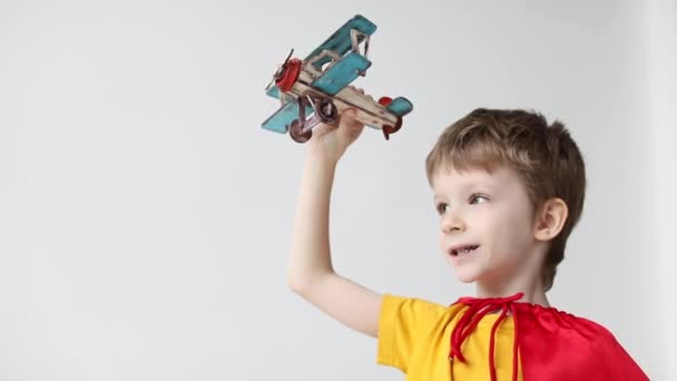 Pequeño Superhéroe Ensueño Una Capa Roja Jugando Juguete Madera Avión — Vídeos de Stock
