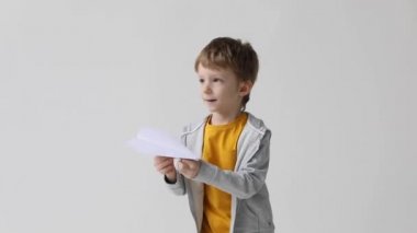 Sevimli küçük çocuk eğleniyor, kağıt uçak fırlatıyor, evcilik oynuyor, bedava seyahat ediyor..