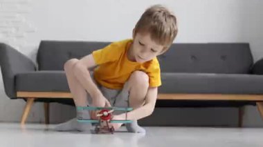 Çocuk evdeki oturma odasında uçakla oynuyor, ağır çekimde.