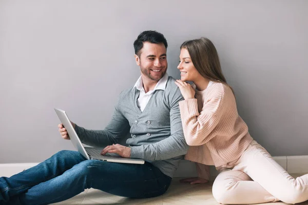 自宅で床に座ってノートパソコンを持つ幸せな若いカップル オンライン教育またはショッピング ロイヤリティフリーのストック写真