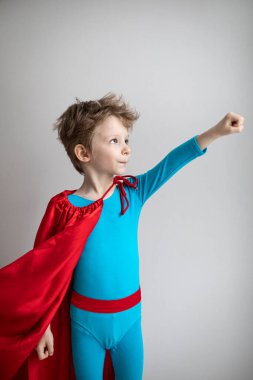 Gri duvarda uçan küçük süper kahraman çocuk. Başarı, motivasyon kavramı.