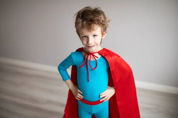 自宅で赤いマントを着たスーパーヒーローの衣装の子供の男の子 動機付けの概念 — ストック写真