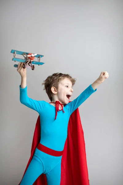 Ребенок Костюме Супергероя Красном Плаще Активно Играет Модель Самолета Концепция — стоковое фото