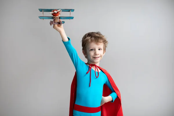 Маленький Супергерой Красном Плаще Играет Самолётом Счастливого Улыбающегося Ребенка Успех — стоковое фото
