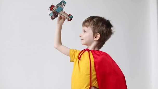 Niño Superhéroe Una Capa Roja Jugar Juguete Madera Avión Volador — Vídeos de Stock