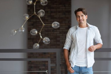 Modern bir evde kendine güvenen genç bir adamın portresi..