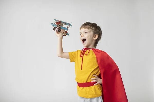 Zasněný Chlapec Červené Pláštěnce Hraje Hračkou Letadla Malý Superhrdina — Stock fotografie