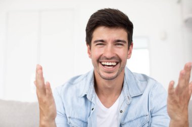 Neşeli adamın dizüstü bilgisayardan bilgisayara ön görüntüsü sohbet uygulaması kullanarak arkadaşınızla veya ortağınızla video iletişimi başlatıyor.