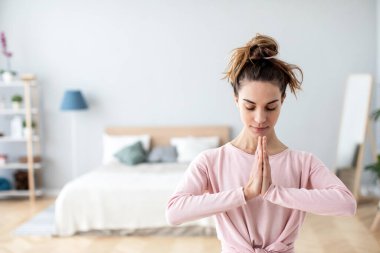 Evdeki dua pozisyonunda genç ve güzel bir kadın. Meditasyon ve rahatlama.