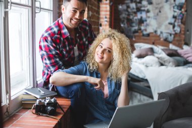 Evde dizüstü bilgisayarı olan genç çift, birlikteliğin tadını çıkarın..
