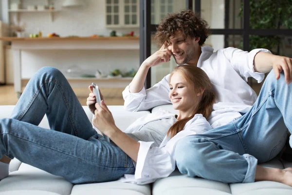 Milenyum çifti kanepeye oturup dijital tablet kullanarak rahatlıyor. Ev hayatının tadını çıkarıyorum..