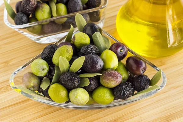 Nye Kornblandinger Oliven Ferske Blader Glassbolle Treoverflate Med Olivenoljeflaske Innhøstingskonsept – stockfoto