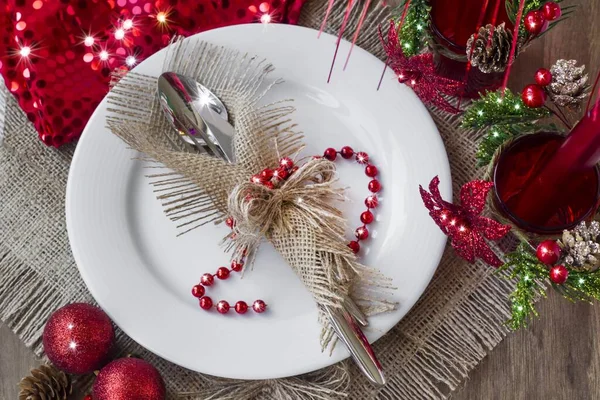 Şık çatal bıçak seti jüt peçeteye sarılı beyaz renkli tabağa çuval bezi yüzeyinde noel süslemeleri, üst görünüm