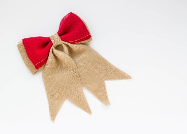 Beyaz yüzeydeki jüt kumaştan yapılmış noel yayı ve kopyalama alanı