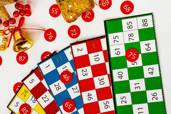 Colorful bingo game cards and numbers on white background with christmas ornaments