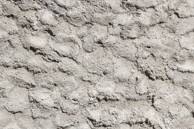 Arka planda mala izleri olan boyanmamış beton duvar.
