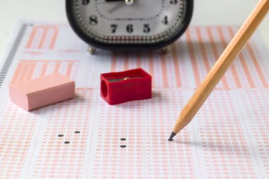 Alarm saati, dolgulu sınav kağıdında tahta kalem ve kauçuk, eğitim sınavının kavramsal görüntüsü.
