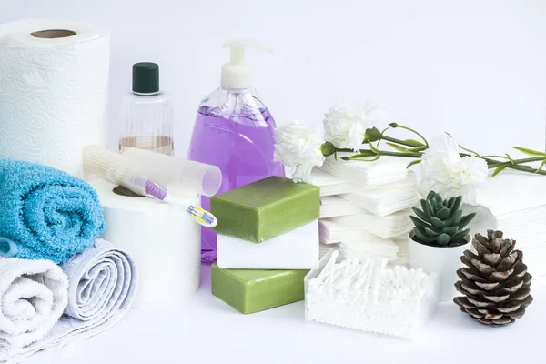 Yuvarlanmış çok renkli banyo ve beyaz arka planda yüz havluları doğal zeytinyağı sabunları ve sıvı sabunlarla.