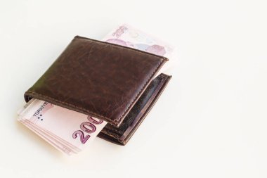 Beyaz yüzey üzerinde deriden bir cüzdanı olan Türk 200 Lira banknotları