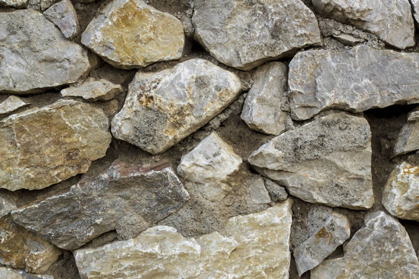 Blank wall made of cement and gray colored shaped stones,close up