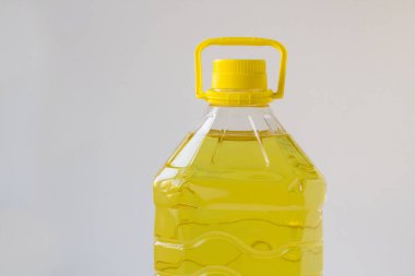 Beyaz arka planda plastik bir şişede beş litre ayçiçeği yağı. kopyalama alanı ile