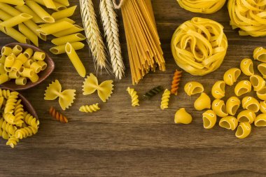 Çeşit çeşit pişirilmemiş makarna veya ahşap masa üzerinde fotokopi alanı, masa üstü
