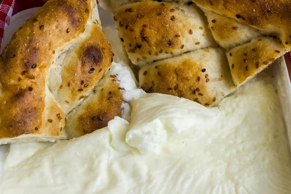 两片传统的土耳其斋月面包 在新鲜酸奶中腌制 — 图库照片