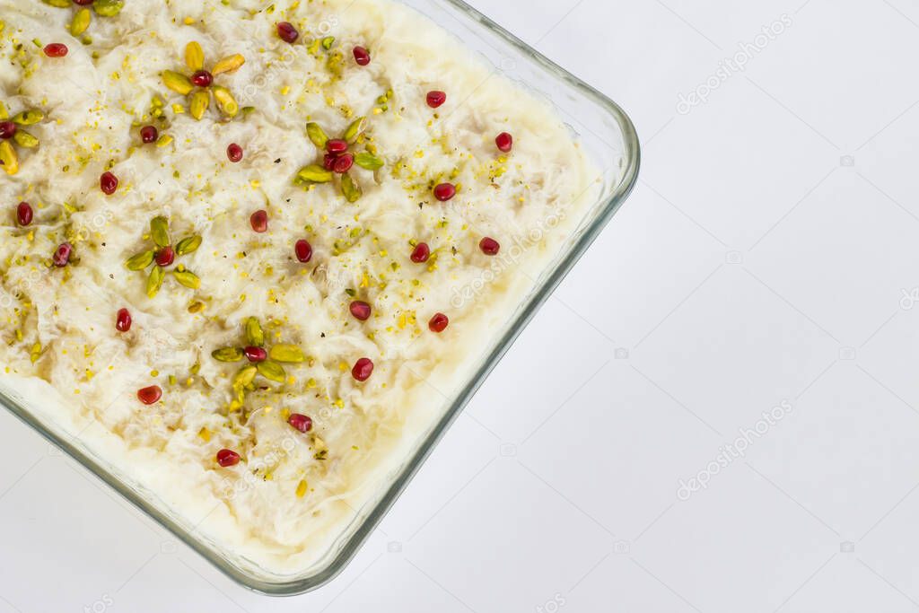 Traditional Turkish Ramadan Milky Dessert,Gullac in glass container on white surface.Top view