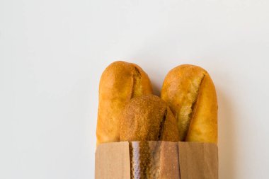 Beyaz bir zemin üzerinde Kraft kağıt torbasında tam buğday ekmeği.