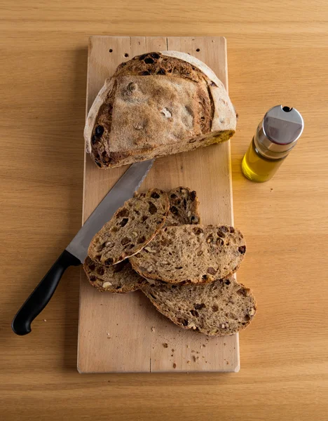 Handmade bread just cut closed to an oil bottle — Stock Photo, Image
