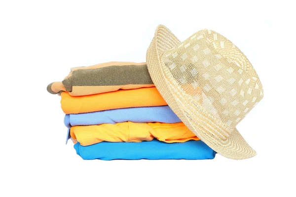 Hög med färgglada kläder med en hatt över vit bakgrund — Stockfoto