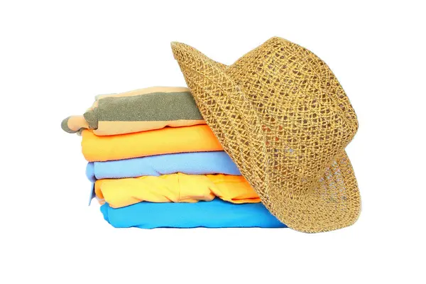 Σωρό από πολύχρωμα ρούχα με ένα καπέλο πάνω από το λευκό φόντο — Φωτογραφία Αρχείου